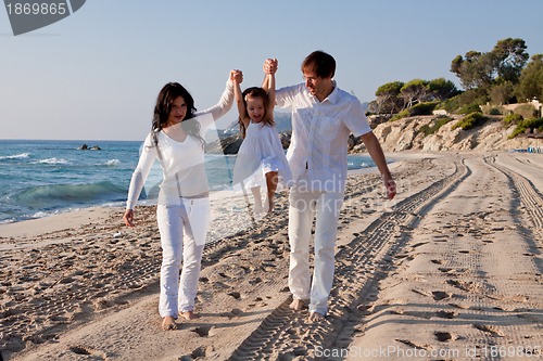 Image of happy young family with daughter on beach in summer
