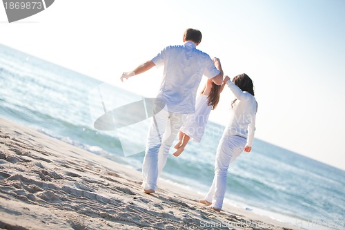 Image of happy young family with daughter on beach in summer
