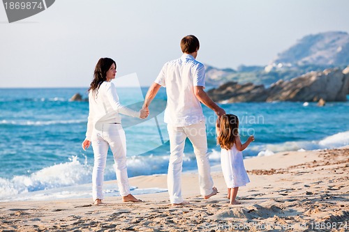 Image of happy young family with daughter on beach in summer