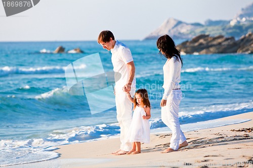 Image of happy young family with daughter on beach in summer