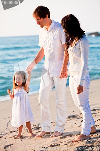 Image of happy young family with daughter on beach in summer