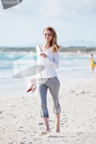Image of beautiful young woman relaxing at beach in summer 