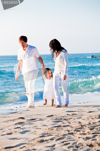 Image of happy young family with daughter on beach in summer