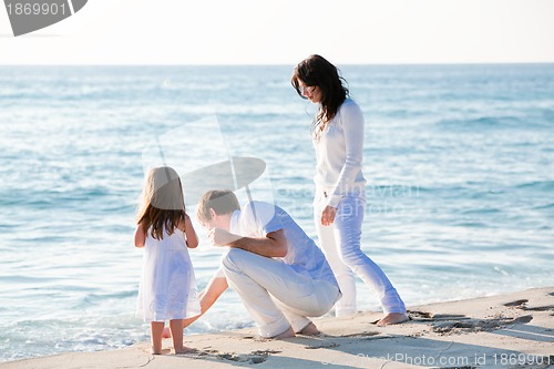 Image of happy young family with daughter on beach in summer