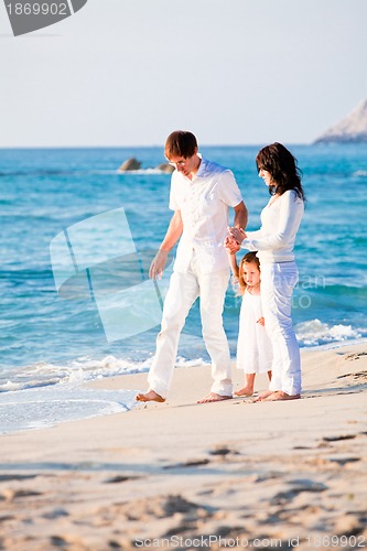 Image of happy young family with daughter on beach in summer