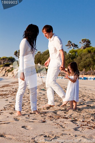 Image of happy young family with daughter on beach in summer