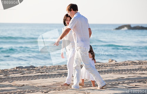 Image of happy young family with daughter on beach in summer
