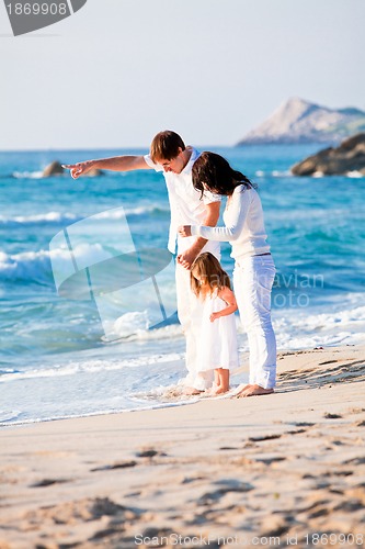Image of happy young family with daughter on beach in summer