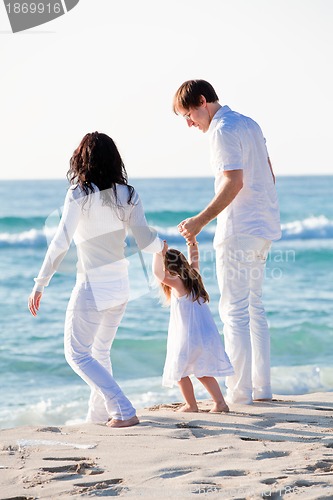 Image of happy young family with daughter on beach in summer