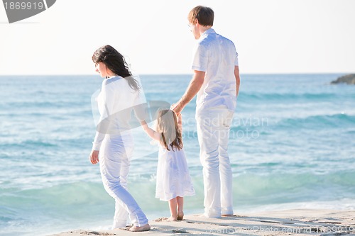 Image of happy young family with daughter on beach in summer