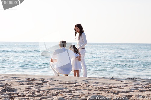 Image of happy young family with daughter on beach in summer