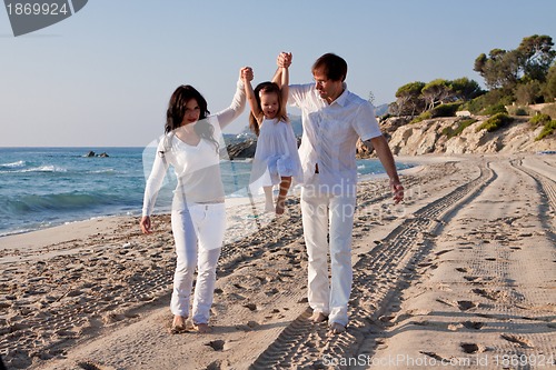 Image of happy young family with daughter on beach in summer