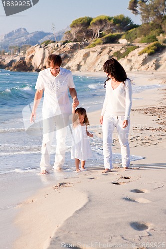 Image of happy young family with daughter on beach in summer