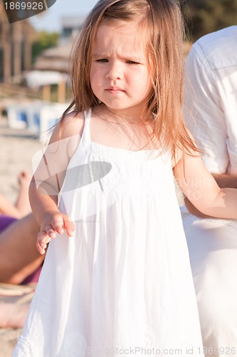 Image of little cute girl smiling playing on beach in summer