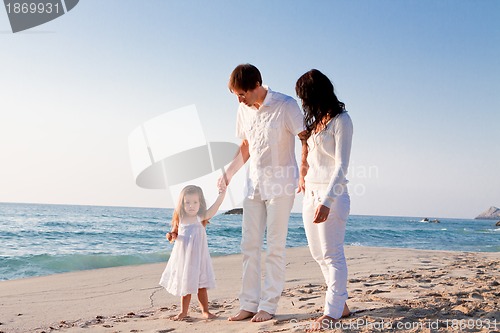 Image of happy young family with daughter on beach in summer