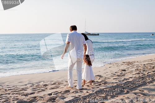 Image of happy young family with daughter on beach in summer