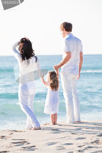 Image of happy young family with daughter on beach in summer