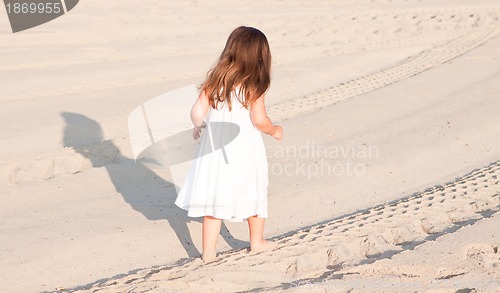 Image of little cute girl smiling playing on beach in summer