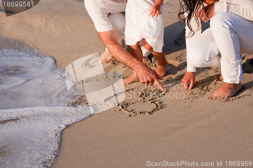 Image of happy young family with daughter on beach in summer