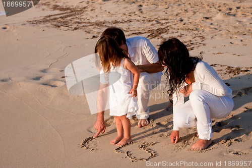 Image of happy young family with daughter on beach in summer