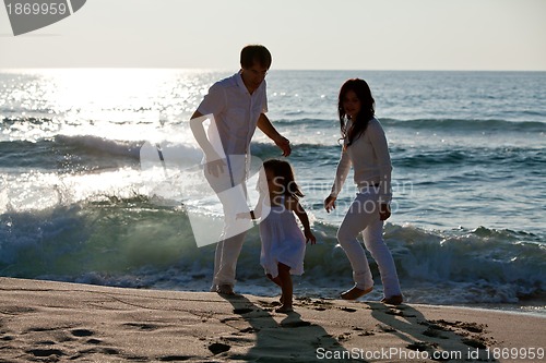 Image of happy young family with daughter on beach in summer