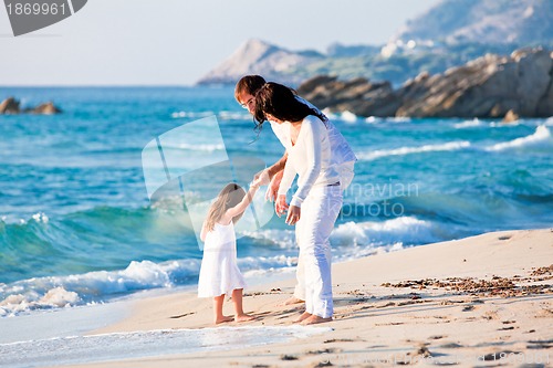 Image of happy young family with daughter on beach in summer