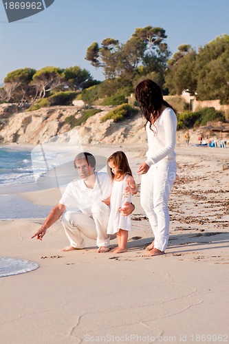 Image of happy young family with daughter on beach in summer