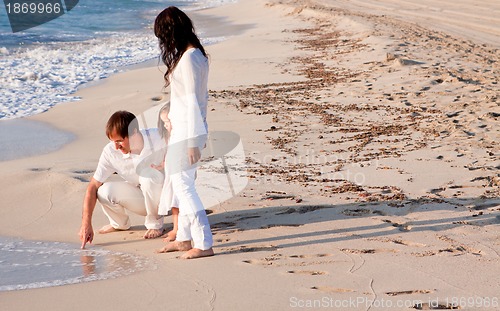 Image of happy young family with daughter on beach in summer