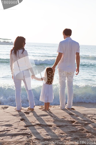 Image of happy young family with daughter on beach in summer