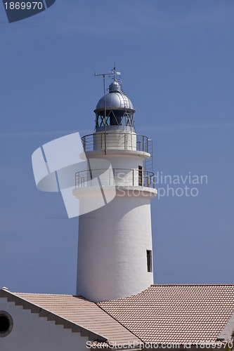 Image of white lighthouse on rocks in the sea ocean water sky blue