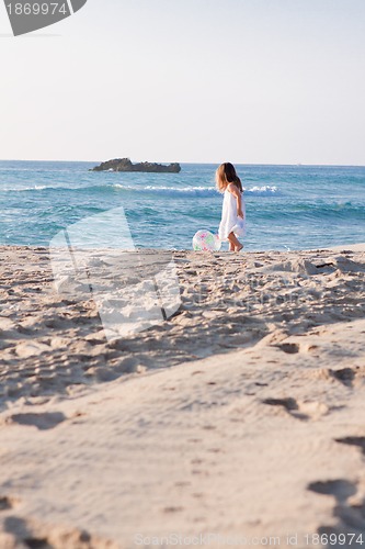 Image of little cute girl smiling playing on beach in summer