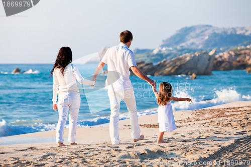 Image of happy young family with daughter on beach in summer