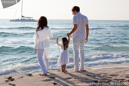 Image of happy young family with daughter on beach in summer
