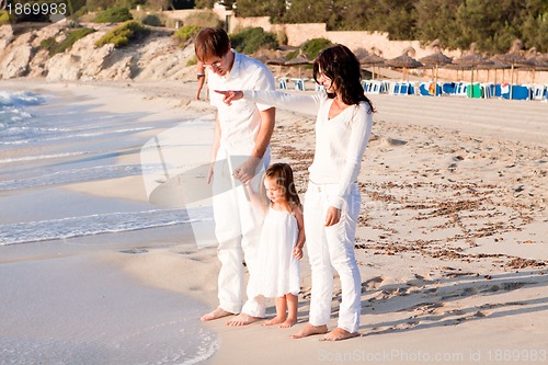 Image of happy young family with daughter on beach in summer