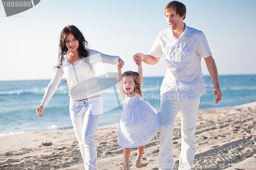Image of happy young family with daughter on beach in summer