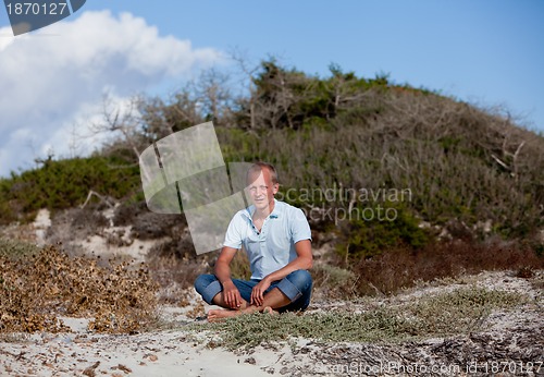 Image of young man is relaxing outdoor in dune in summer