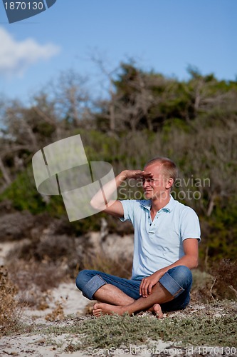 Image of young man is relaxing outdoor in dune in summer