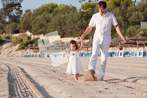 Image of happy family father and daughter on beach having fun