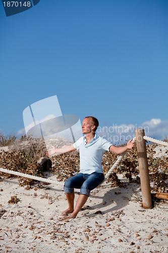 Image of young man is relaxing outdoor in dune in summer