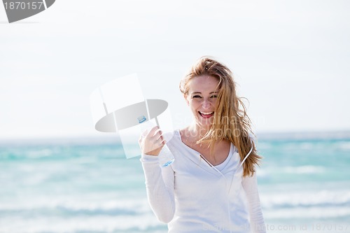 Image of beautiful young woman drinking water in summer 