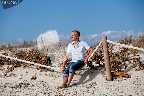 Image of young man is relaxing outdoor in dune in summer