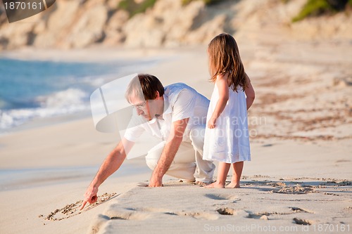 Image of happy family father and daughter on beach having fun