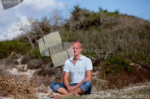 Image of young man is relaxing outdoor in dune in summer