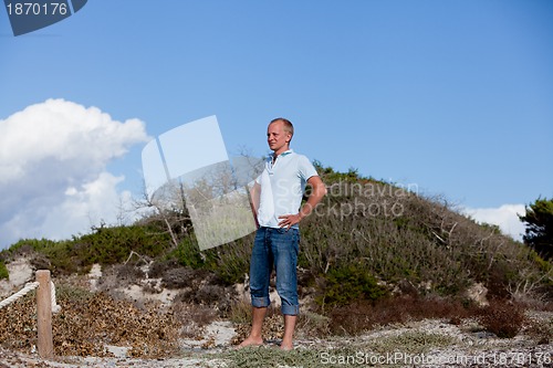 Image of young man is relaxing outdoor in dune in summer