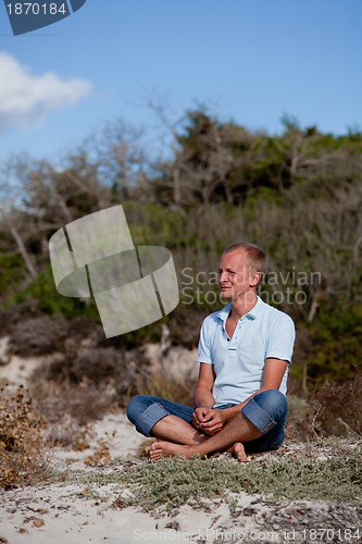 Image of young man is relaxing outdoor in dune in summer