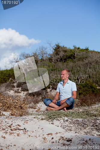 Image of young man is relaxing outdoor in dune in summer