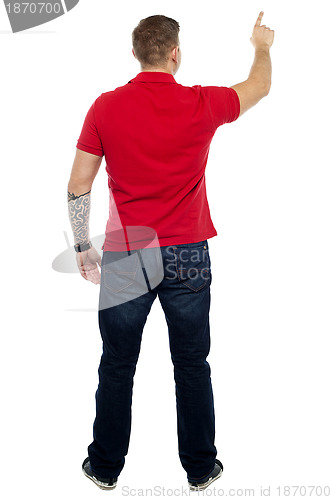 Image of Back pose of man pointing at copy space area