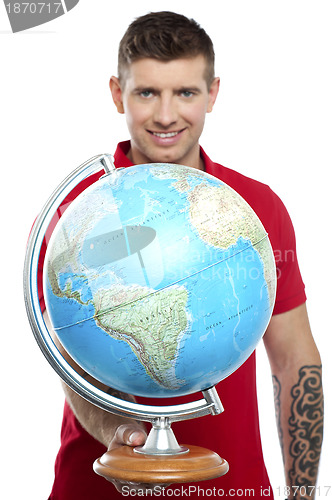Image of Guy with tattoos showing globe to camera
