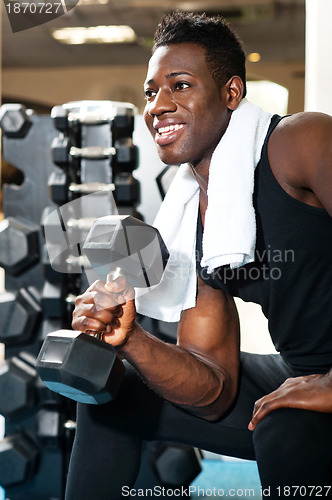 Image of Young gym instructor toning his biceps