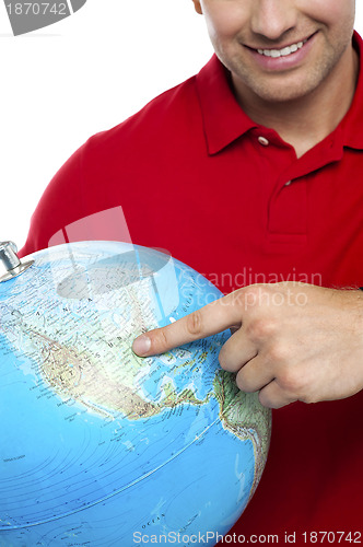 Image of Cropped image smiling man pointing at the globe